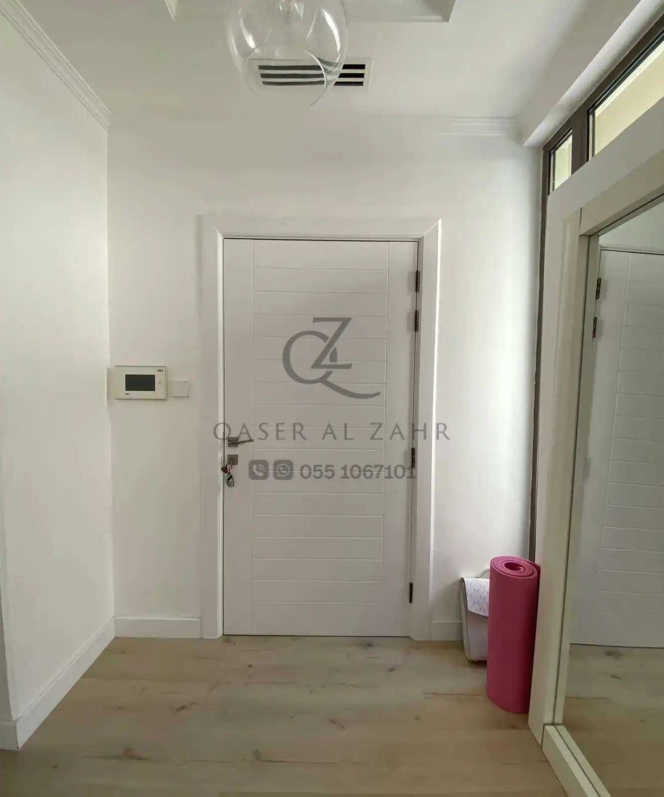 Glass door with white frame opening to modern outdoor area under work progress